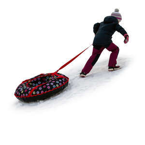 cut out little girl climbing up a snowy hill with her sledge