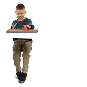 cut out little boy at a ceramics class sitting