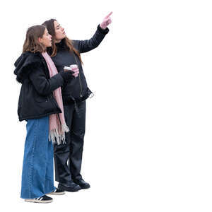 two young women with coffee cups standing and pointing at smth