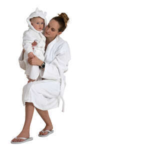 woman and her baby son in white bathrobes sitting