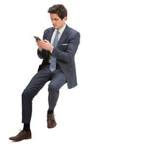 man in a suit sitting on a barstool