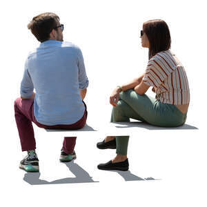two backlit people sitting seen from back angle