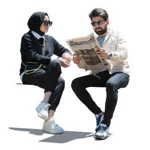 man and woman sitting and reading newspaper
