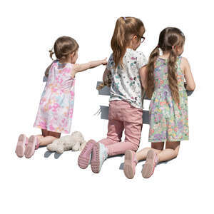 three girls kneeling on the bench and looking at smth