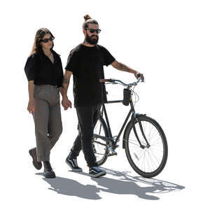 backlit couple with a bike walking hand in hand