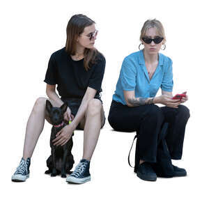two women and a dog sitting and talking