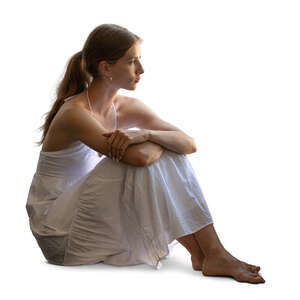 backlit woman in a white dress sitting by the window