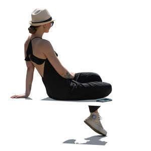 backlit woman with a hat sitting