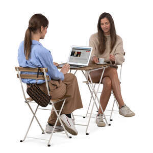 two women sitting in a coffeeshop with laptop