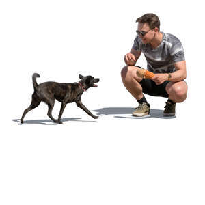 man squatting and playing with his dog