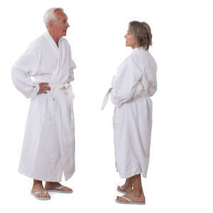 senior man and woman in white bathrobes standing and talking