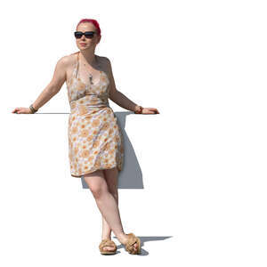 woman in a dress leaning on a balcony railing