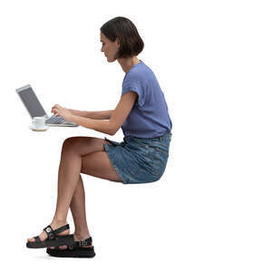 woman sitting at a  table and working with computer and drinking coffee