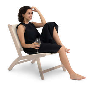 woman in a black dress sitting casually and drinking wine