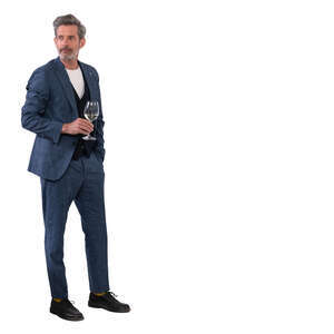 man in a suit standing and drinking wine
