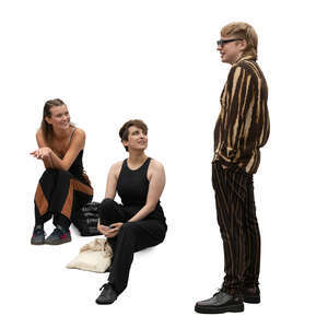 two women sitting on stairs and talking to a young man