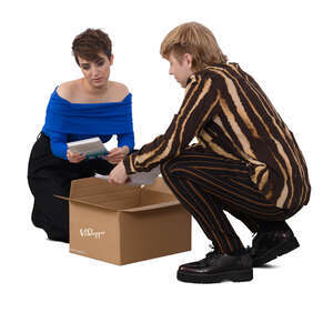 two people squatting and taking books out from a box