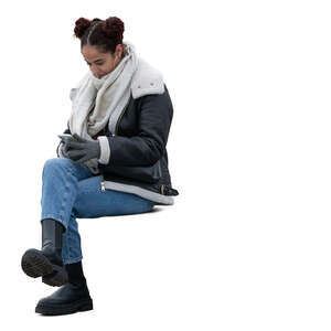 woman sitting outside in winter and texting