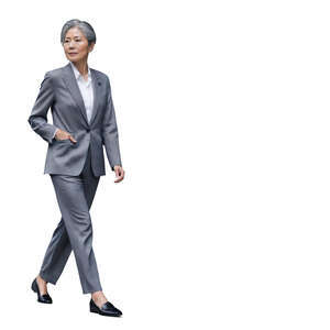 older japanese woman wearing a business costume walking