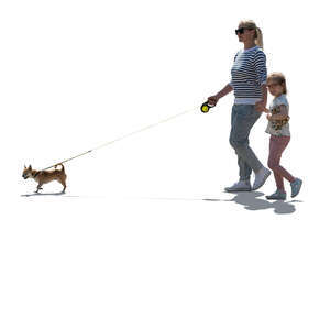 backlit mother and daughter walking hand in hand and walking a dog
