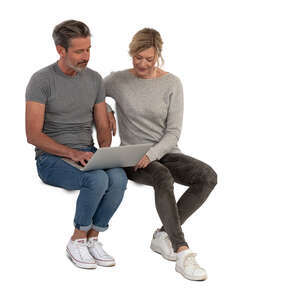 man and woman sitting and looking at laptop together