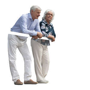 two elderly people standing up on a balcony and leaning on a railing