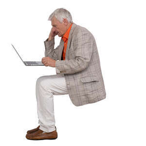 elderly gentleman sitting and working with laptop