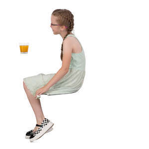 little girl sitting in a cafe and drinking juice