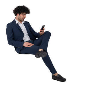 man in a suit sitting and holding a phone