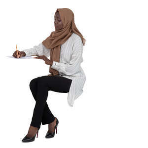 cut out muslim woman sitting behind the desk and writing