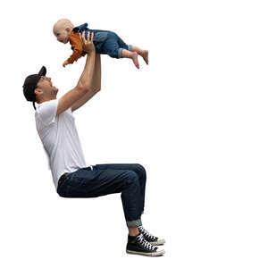 man sitting holding a baby up in the air 