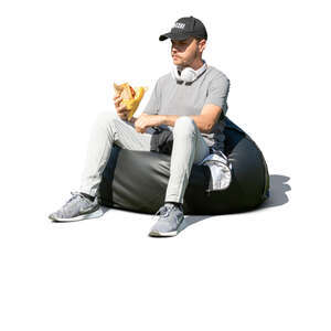 young man sitting and eating a hamburger