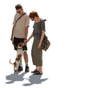 backlit man and woman petting a dog