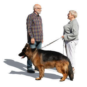 two elderly people with a dog standing