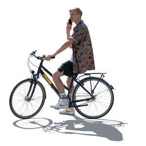 backlit man riding a bike and talking on a phone