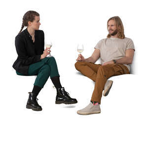 two people sitting on a sofa and drinking wine