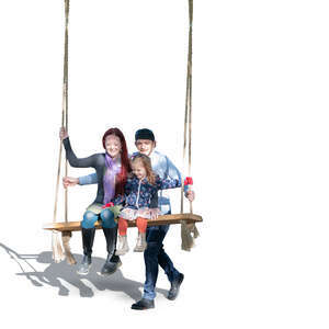 family sitting on a swing in a park