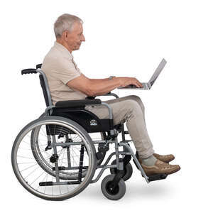 older man sitting in a wheelchair and working with computer