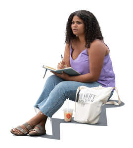 young black woman sitting and writing in her notebook