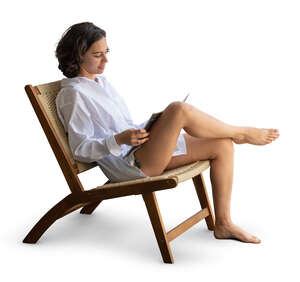 cut out woman sitting in a armchair by the window and reading
