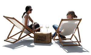 two people sitting on the patio in sling chairs and drinking wine