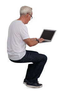 older gentleman sitting at a desk and working with a computer