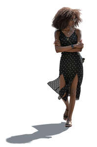 backlit black woman in a dress walking
