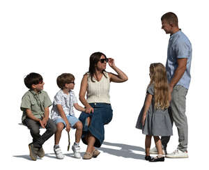 woman and kids sitting and talking to friends standing by