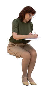 older woman sitting behind the desk and writing