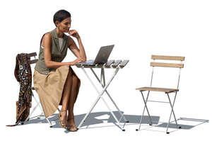 woman sitting outside behind the table with a laptop