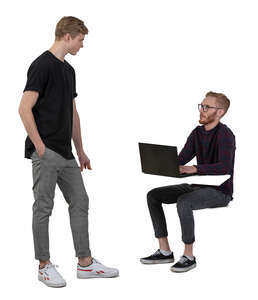 two men talking at the office while one is sitting behind the desk