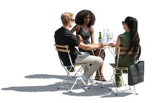 backlit group of three sitting in a restaurant