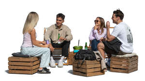 group of young people sitting outside and eating watermelon