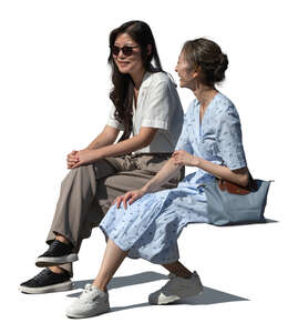 two cut out asian women sitting and talking